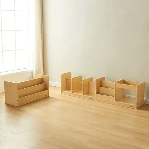 Set of wooden children's furniture pieces on a wooden floor with a window in the background.