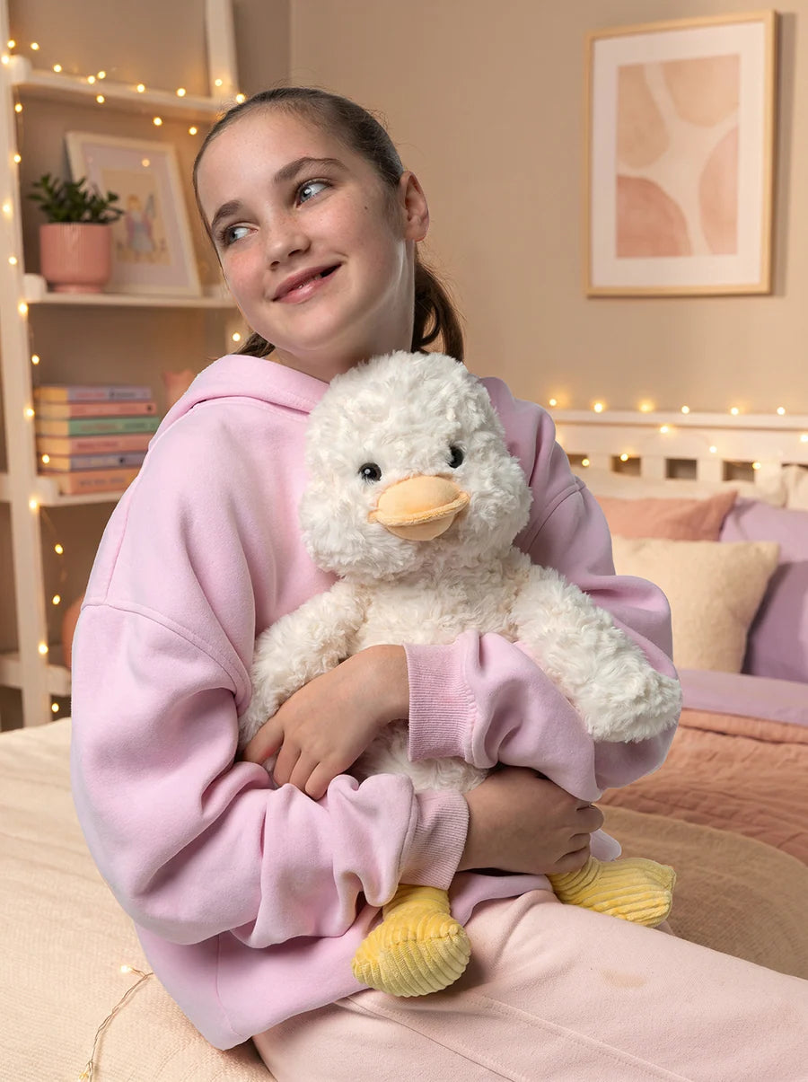 Young girl cuddling the Mini & Me Ducky Devotion weighted plush duck, enjoying a comforting sensory experience.