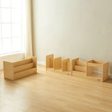 Set of wooden children's furniture pieces on a wooden floor with a window in the background.